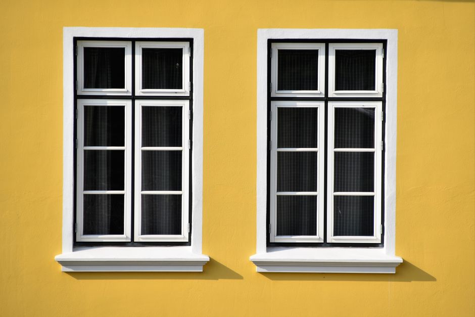 Two white-framed windows set in a painted wall